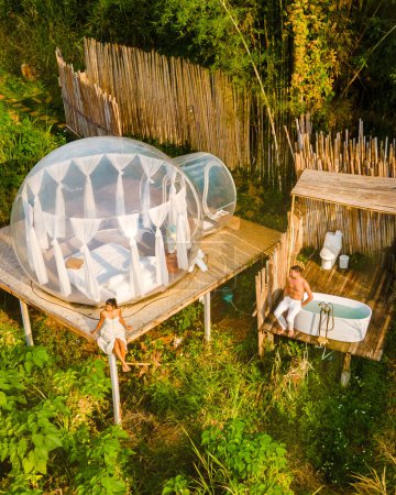 Photo for Couple man and women in a tent with a jacuzzi in the jungle rainforest. Luxury glamping - Royalty Free Image