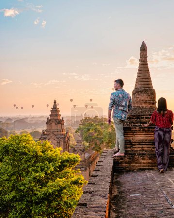 Photo for Bagan Myanmar, Sunrise above temples and pagodas of Bagan Myanmar, Sunrise Pagan Myanmar temple and pagoda. Men and woman at an old pagoda during a vacation in Myanmar, couple visit a temple in Bagan - Royalty Free Image