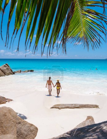 Foto de Anse Lazio Praslin Seychelles, una joven pareja de hombres y mujeres en una playa tropical durante unas vacaciones de lujo en Seychelles. Playa tropical Anse Lazio Praslin Islas Seychelles - Imagen libre de derechos