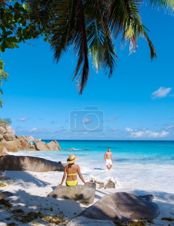 Foto de Anse Lazio Praslin Seychelles, una joven pareja de hombres y mujeres en una playa tropical durante unas vacaciones de lujo en Seychelles. Playa tropical Anse Lazio Praslin Islas Seychelles - Imagen libre de derechos