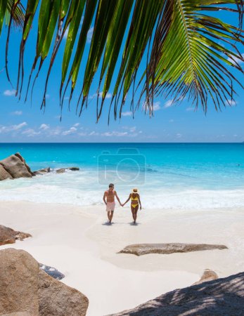 Foto de Anse Lazio Praslin Seychelles, una joven pareja de hombres y mujeres en una playa tropical durante unas vacaciones de lujo en las Seychelles. Playa tropical Anse Lazio Praslin Islas Seychelles - Imagen libre de derechos