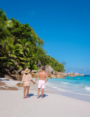 Foto de Anse Lazio Praslin Seychelles, una joven pareja de hombres y mujeres en una playa tropical durante unas vacaciones de lujo en Seychelles. Playa tropical Anse Lazio Praslin Islas Seychelles en un día soleado - Imagen libre de derechos