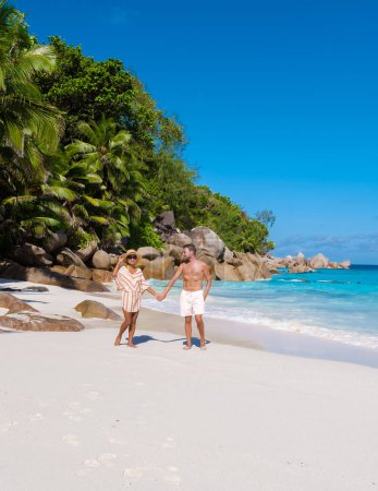 Photo for Anse Lazio Praslin Seychelles, a young couple of men and women on a tropical beach during a luxury vacation in Seychelles. Tropical beach Anse Lazio Praslin Seychelles Islands on a sunny day - Royalty Free Image