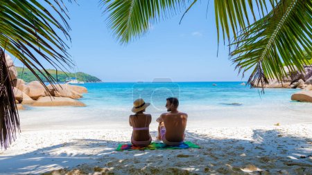 Foto de Una joven pareja de hombres y mujeres en una playa tropical durante unas vacaciones de lujo en las Seychelles. Playa tropical Anse Lazio Praslin Islas Seychelles - Imagen libre de derechos