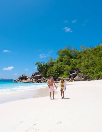 Foto de Anse Lazio Praslin Seychelles es una joven pareja de hombres y mujeres en una playa tropical durante unas vacaciones de lujo allí. Playa tropical Anse Lazio Praslin Seychelles Islas tropicales - Imagen libre de derechos