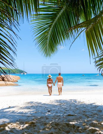Foto de Anse Lazio Praslin Seychelles es una joven pareja de hombres y mujeres en una playa tropical durante unas vacaciones de lujo allí. Playa tropical Anse Lazio Praslin Seychelles Islas tropicales - Imagen libre de derechos
