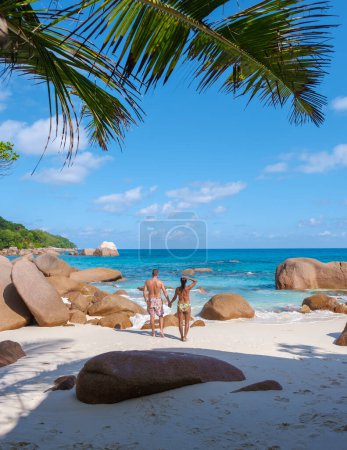 Photo for Anse Lazio Praslin Seychelles a young couple of men and women on a tropical beach during a luxury vacation there. Tropical beach Anse Lazio Praslin Seychelles Islands on a sunny day with a blue sky - Royalty Free Image