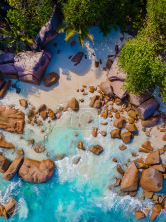 Foto de Anse Lazio Praslin Seychelles, una joven pareja de hombres y mujeres en una playa tropical durante unas vacaciones de lujo en las Seychelles. Playa tropical Anse Lazio Praslin Seychelles Islas vista aérea drone - Imagen libre de derechos