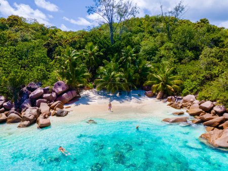 Foto de Anse Lazio Praslin Seychelles, una joven pareja de hombres y mujeres en una playa tropical durante unas vacaciones de lujo en las Seychelles. Playa tropical Anse Lazio Praslin Islas Seychelles vista drone - Imagen libre de derechos