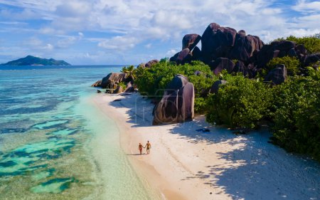 Foto de Anse Source dArgent, La Digue Seychelles, una joven pareja de hombres y mujeres en una playa tropical durante unas vacaciones de lujo en Seychelles. vista del dron desde arriba en una playa tropical - Imagen libre de derechos