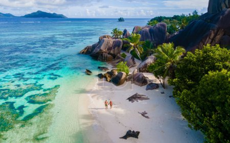 Téléchargez les photos : Anse Source dArgent, La Digue Seychelles, un jeune couple d'hommes et de femmes sur une plage tropicale, vue aérienne d'un drone d'une plage tropicale aux Seychelles - en image libre de droit