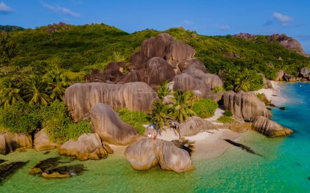 Foto de Anse Source dArgent, La Digue Seychelles, una joven pareja de hombres y mujeres en una playa tropical durante unas vacaciones de lujo en las Seychelles. - Imagen libre de derechos
