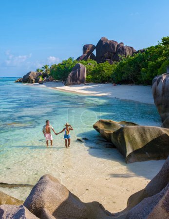 Foto de Anse Source dArgent, La Digue Seychelles, una joven pareja de hombres y mujeres en una playa tropical durante unas vacaciones de lujo en Seychelles. Playa tropical Anse Source dArgent, La Digue Seychelles - Imagen libre de derechos