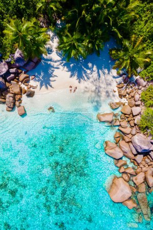 Foto de Anse Lazio Praslin Seychelles es una joven pareja de hombres y mujeres en una playa tropical durante unas vacaciones de lujo allí. Playa tropical Anse Lazio Praslin Islas Seychelles en un día soleado - Imagen libre de derechos