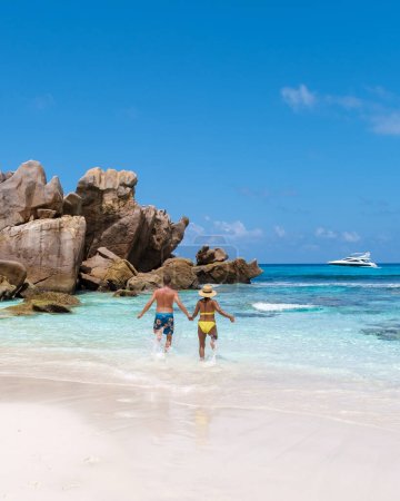 Foto de Anse Cocos La Digue Seychelles, una joven pareja de hombres y mujeres en una playa tropical durante unas vacaciones de lujo en Seychelles. Playa tropical Anse Cocos La Digue Seychelles con un océano azul - Imagen libre de derechos