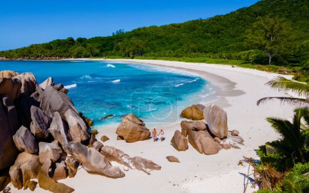 Photo for Anse Cocos La Digue Seychelles, a young couple of men and women on a tropical beach during a luxury vacation in Seychelles. Tropical beach Anse Cocos La Digue Seychelles with a blue ocean - Royalty Free Image