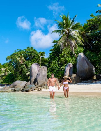 Téléchargez les photos : Plage tropicale avec palmiers et un océan bleu à Mahe Seychelles. Anse Royale plage, couple homme et femme en vacances Seychelles. - en image libre de droit