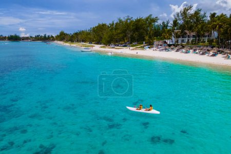 Téléchargez les photos : Vacances à Maurice, couple homme et femme en kayak dans un océan bleu à Maurice. hommes et femmes faisant du colportage dans une turquouse colorée de l'île Maurice pendant les vacances de lune de miel - en image libre de droit