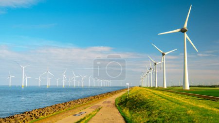 Photo for Windmill turbines at sea are seen from a drone aerial view from above at a huge windmill park in the Netherlands - Royalty Free Image