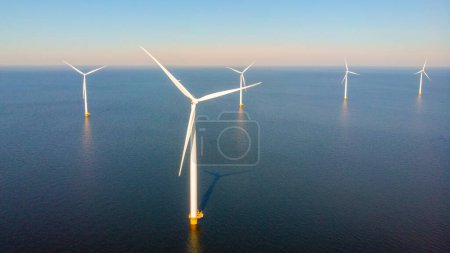 Téléchargez les photos : Parc éolien offshore avec nuages et un ciel bleu, parc éolien dans l'océan vue aérienne avec éolienne Flevoland Pays-Bas Ijsselmeer. Énergie verte aux Pays-Bas - en image libre de droit