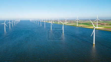 Photo for Windmill park with clouds and a blue sky, windmill park in the ocean drone aerial view with wind turbine Flevoland Netherlands Ijsselmeer. Green Energy in the Netherlands - Royalty Free Image