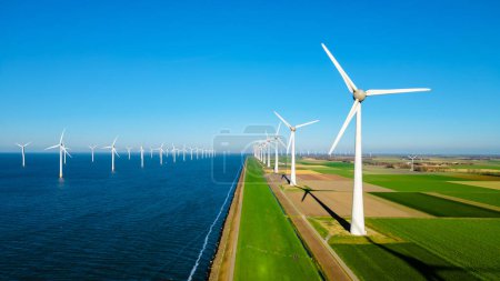 Foto de Parque de molinos de viento en alta mar con nubes y un cielo azul, parque de molinos de viento en la vista aérea del océano con turbina eólica Flevoland Países Bajos Ijsselmeer. Energía verde en los Países Bajos - Imagen libre de derechos