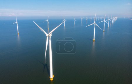 Foto de Parque de molinos de viento en alta mar con nubes y un cielo azul, parque de molinos de viento en la vista aérea del océano con turbina eólica Flevoland Países Bajos Ijsselmeer. Energía verde en los Países Bajos en un día soleado - Imagen libre de derechos