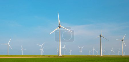 Photo for Windmill park with clouds and a blue sky, windmill park in the ocean aerial view with wind turbine Flevoland Netherlands Ijsselmeer. Green Energy production in the Netherlands - Royalty Free Image