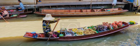 Foto de Tenedores de puestos de mercado en pequeñas embarcaciones que venden frutas y verduras locales, Damnoen Saduak Floating Market, Tailandia - Imagen libre de derechos