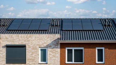 Photo for Newly build houses with black solar panels on the roof against a sunny sky Close up of new building with black solar panels. Zonnepanelen, Zonne energie, Translation: Solar panel, , Sun Energy - Royalty Free Image