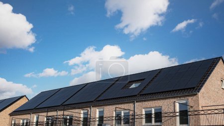 Foto de Casas de nueva construcción con paneles solares adosados en el tejado Cierre de nuevo edificio con paneles solares negros. Zonnepanelen, Zonne energie, Traducción: Panel solar,, Sun Energy - Imagen libre de derechos