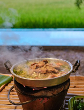 Téléchargez les photos : Barbecue coréen thaïlandais avec un regard sur les rizières vertes dans une famille d'accueil dans une ferme en Thaïlande - en image libre de droit