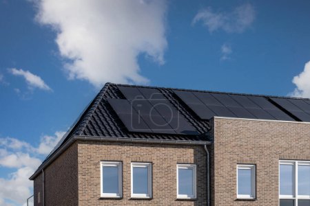 Téléchargez les photos : Maisons nouvellement construites avec des panneaux solaires fixés sur le toit contre un ciel ensoleillé aux Pays-Bas - en image libre de droit