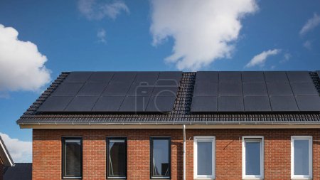 Photo for Newly build houses with solar panels attached on the roof Close up of new building with black solar panels. Zonnepanelen, Zonne energie, Translation: Solar panel, , Sun Energy - Royalty Free Image