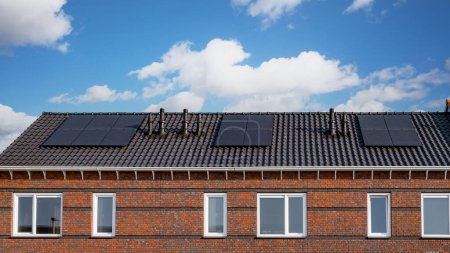 Téléchargez les photos : Maisons nouvellement construites avec des panneaux solaires fixés sur le toit Gros plan du nouveau bâtiment avec des panneaux solaires noirs. Zonnepanelen, Zonne energie, Traduction : Panneau solaire,, Énergie solaire - en image libre de droit