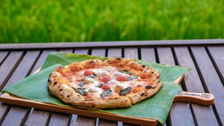 Photo for Pizza at a farm stay in Thailand with green rice fields, homemade pizza. - Royalty Free Image
