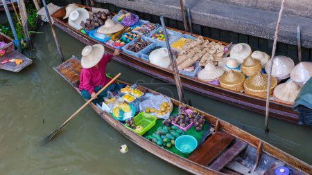 Photo for Market stall holders in small boats selling local fruits and vegetables, Damnoen Saduak Floating Market, Thailand in the morning light - Royalty Free Image