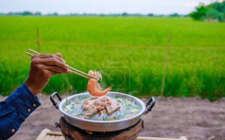 Foto de Primer plano de una barbacoa coreana tailandesa con una mirada sobre los campos de arroz verde en una casa de familia en una granja en Tailandia - Imagen libre de derechos