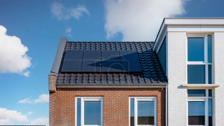 Foto de Casas de nueva construcción con paneles solares unidos en el techo, paneles solares fotovoltaicos en un techo de la casa - Imagen libre de derechos