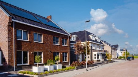 Téléchargez les photos : Maisons nouvellement construites avec des panneaux solaires fixés sur le toit, panneaux solaires photovoltaïques sur un toit de maison - en image libre de droit