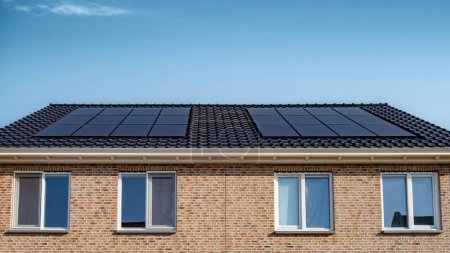 Foto de Casas de nueva construcción con paneles solares unidos en el techo, paneles solares que producen energía limpia en un techo de una casa residencial - Imagen libre de derechos