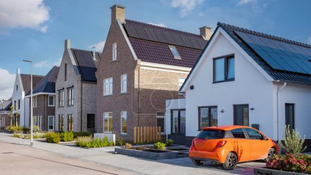 Téléchargez les photos : Maisons nouvellement construites avec des panneaux solaires fixés sur le toit, panneaux solaires produisant de l'énergie propre sur un toit d'une maison résidentielle - en image libre de droit