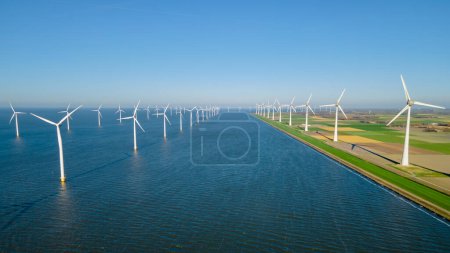 Foto de Parque de molinos de viento con nubes y cielo azul, parque de molinos de viento en la vista aérea del océano con turbina eólica verde Producción de energía en los Países Bajos - Imagen libre de derechos