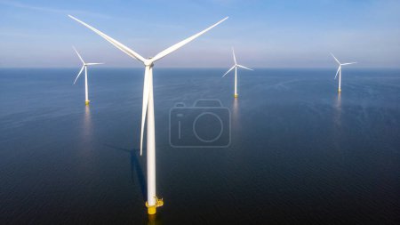 Foto de Aerogenerador desde la vista aérea, Drone vista en el parque eólico westermeerdijk una granja de molinos de viento en el lago IJsselmeer el más grande de los Países Bajos, Desarrollo sostenible, energías renovables - Imagen libre de derechos