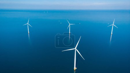 Photo for Offshore Windmill farm in the ocean Westermeerwind park , windmills isolated on a beautiful bright day Netherlands Flevoland Noordoostpolder - Royalty Free Image