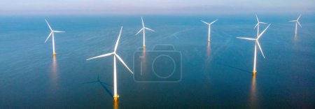 Foto de Vista del dron en el parque del molino de viento con nubes y un cielo azul, parque del molino de viento en la vista aérea del océano con turbina eólica Flevoland Países Bajos Ijsselmeer. Producción de energía verde en los Países Bajos - Imagen libre de derechos