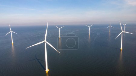 Foto de Parque de molinos de viento con nubes y un cielo azul, parque de molinos de viento en la vista aérea del océano con turbina eólica Flevoland Países Bajos Ijsselmeer. Producción de energía verde en los Países Bajos - Imagen libre de derechos
