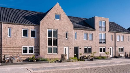 Foto de Zona suburbana holandesa con casas familiares modernas, casas de ladrillo modernas en un barrio suburbano familiar en los Países Bajos. - Imagen libre de derechos