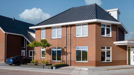 Téléchargez les photos : Zone de banlieue néerlandaise avec maisons familiales modernes, maisons familiales modernes nouvellement construites aux Pays-Bas, maison familiale aux Pays-Bas, maisons nouvellement construites dans un quartier de banlieue moderne convivial pour la famille - en image libre de droit