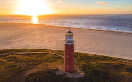 Photo for Texell lighthouse during sunset Netherlands Dutch Island Texel in summer with sand dunes at the Wadden Island. drone aerial view from above - Royalty Free Image